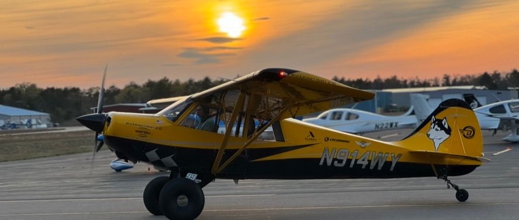 Yellow husky aircraft in front of a setting sun